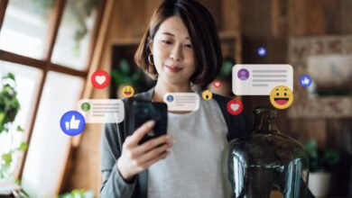 Beautiful young Asian woman using smartphone in the living room at home, checking social media on mobile phone, receives notification, likes, views and comments. Youth lifestyle, social media and digital online. People network and technology
